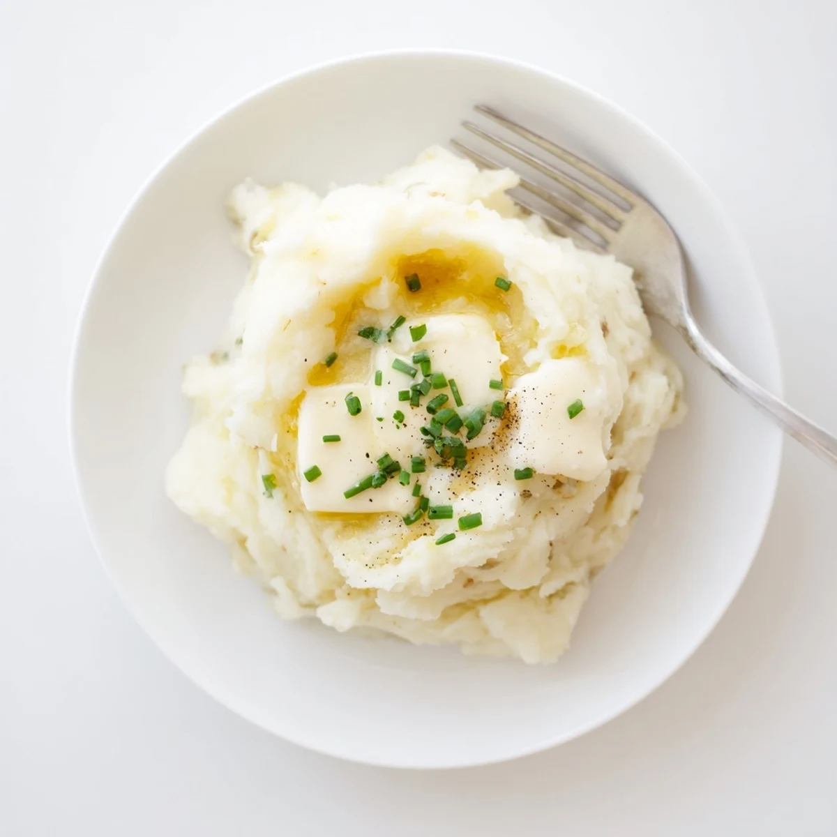 Fluffy mashed potatoes, steaming in a bowl, ready for serving.