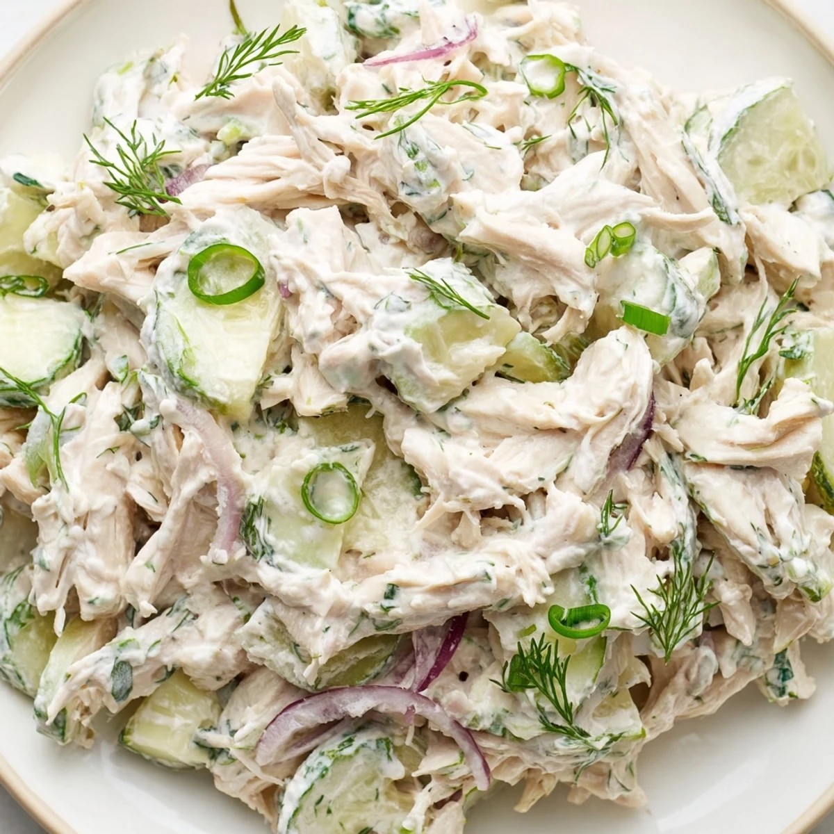 Close up view of Creamy Cucumber Chicken Salad showing creamy dressing coating tender chicken and thinly sliced cucumbers.