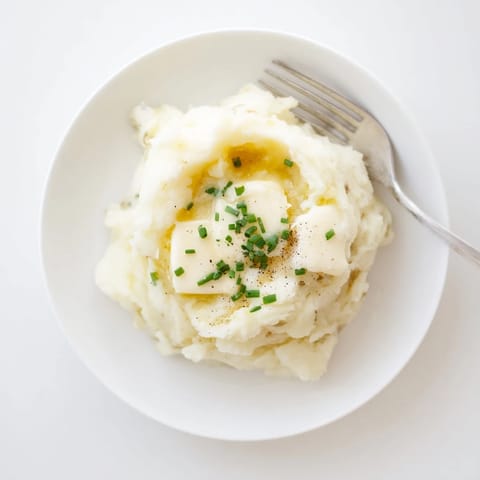 Fluffy mashed potatoes, steaming in a bowl, ready for serving.