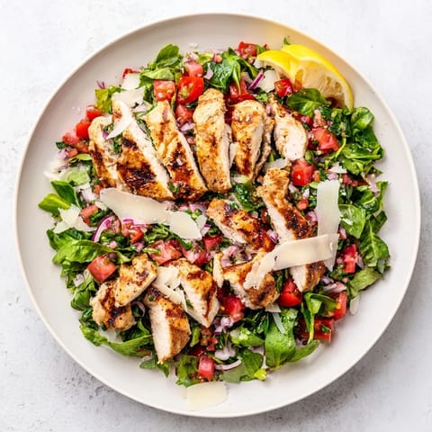 Savory grilled chicken rests on crisp greens, finished with a juicy tomato-basil bruschetta topping in this Bruschetta Chicken Salad.  