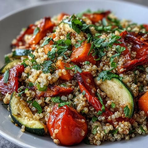 Colorful roasted vegetables like zucchini, bell peppers, and cherry tomatoes mingle with fluffy quinoa in this vibrant vegetable pilaf.  