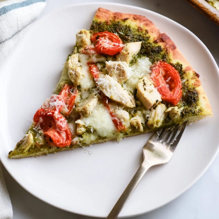 Sliced Chicken Pesto Pizza reveals tender chicken pieces, fragrant basil pesto, and bubbling cheese.