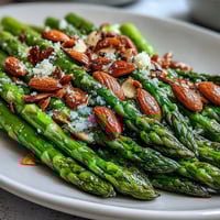 Fresh asparagus sautéed in lemon butter, topped with golden toasted almonds for a bright spring side dish.
